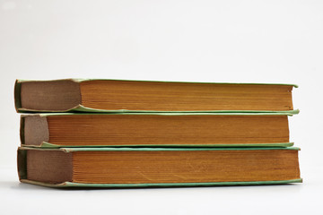 Three old books stacked on white background