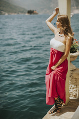 Young attractive woman in a dress relaxing by the sea