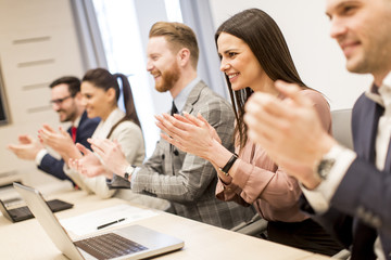 Group of business people clapping their hands at the meeting