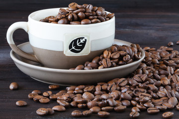 Close up of cup of espresso with fresh beans on a wooden table