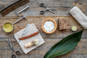 Barber workplace. Shaving brush, razor, foam, sciccors on wooden table background top view