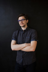 Obraz premium Young adult guy in glasses. Business portrait on textured black background