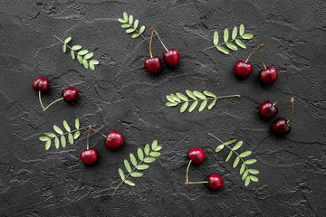 Berry pattern. Cherry and leaves on black table background top view