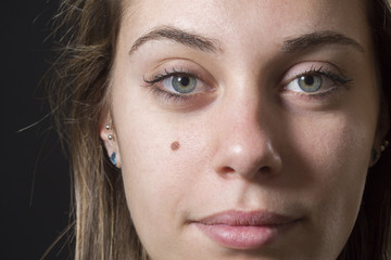 giovane e bella ragazza che guarda con sguardo enigmatico in macchina - sfondo nero