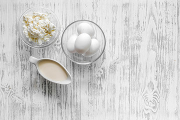 Natural food. Milk, cottage, eggs on light wooden background top view copyspace