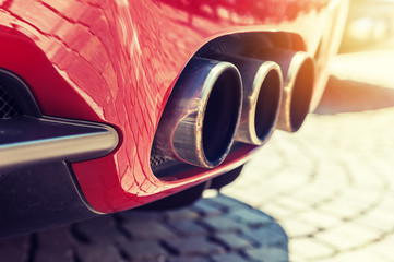 Close up of a car dual exhaust pipe in sunlight