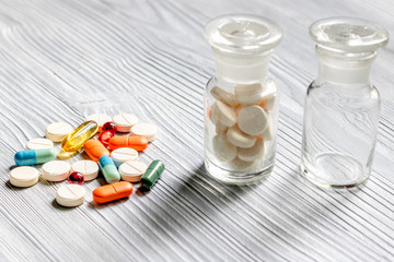 Pills and pill bottle on grey table background
