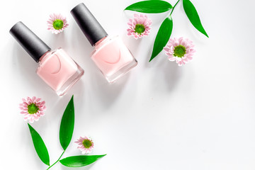 Pink nail polish on white table background top view copyspace