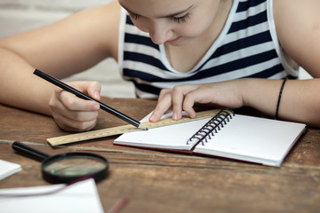 Schoolgirl doing homework at the table