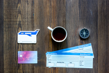Naklejka premium Preparing for trip. Tickets, compass, bank card on wooden table background top view