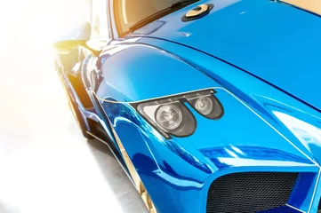 Foto op Plexiglas Snelle auto Font of a blue sport luxury car in sunset light