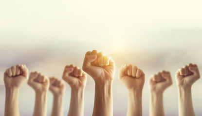 Peoples raised fist air fighting and sunlight effect, Competition, teamwork concept, background...