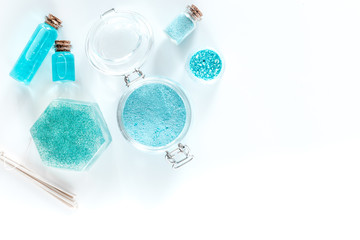 Spa set with sea salt, blue clay and lotion on white background top view copyspace