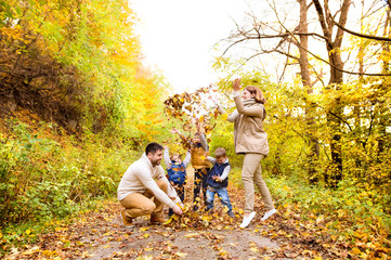 Beautiful young family on a walk in autumn forest.