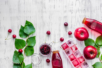 Summer ice tea with apple, cranberry and cherry on wooden table top view copyspace