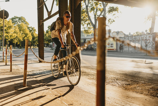 Radfahrer f&auml;hrt mit Singlespeed bei Sonnenuntergang durch die Stadt