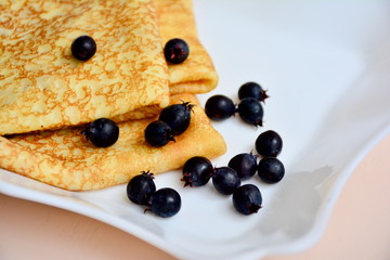 Pancakes and shadberries on white plate