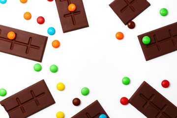 sweet chocolate bar and color candy in white background top view