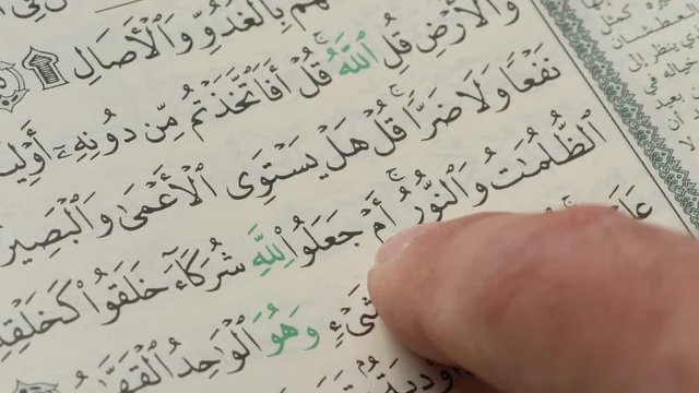 Reading a verse from a Quran. Closeup shot of a finger passing on the page.
