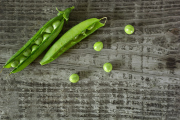 young juicy green peas on a wooden table. copy space