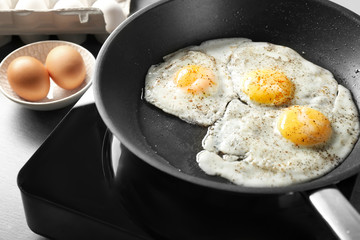 Delicious over easy eggs in pan on stove