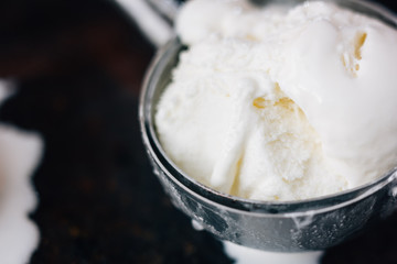 Ice cream starting to melt in metal ice cream scoop.
