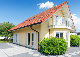 gelbes Einfamilienhaus mit Balkon