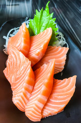 Japanese food: salmon sashimi (fresh raw salmon meat) decorated with grated turnip and mint leaf on...