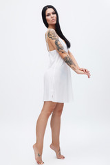 Woman with tattoos wearing nightgown