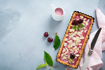 Summer tart with cherry custard on a gray deton background. Selective focus.Top view. Copy space.
