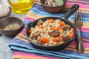 Devzira pilaf with lamb, onions, carrots and spices (cumin, coriander, pepper). Traditional dishes of Uzbek cuisine. Selective focus