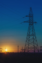 high-voltage power lines at sunset.