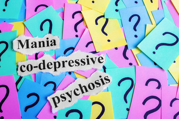 Mania co-depressive psychosis Syndrome text on colorful sticky notes Against the background of question marks
