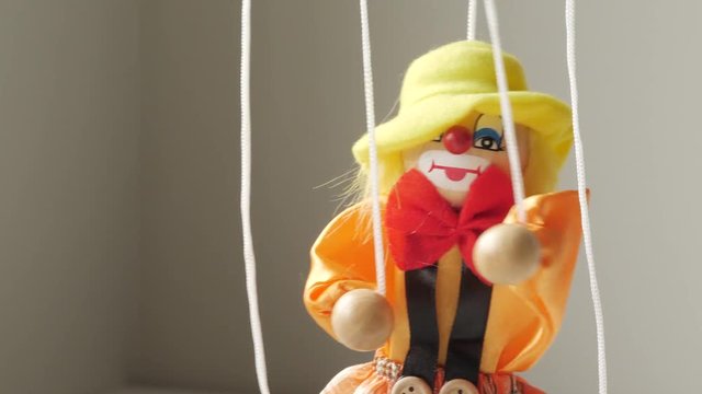 Funny clown string puppet moving around. Closeup shot.