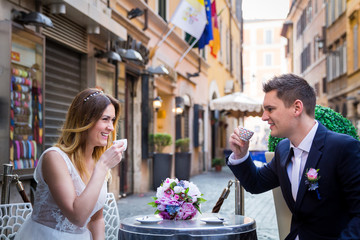 Bride and groom on a table drinking coffee in Rome, Italy