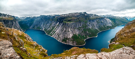 Fototapeta na wymiar Panoramic aerial wide angle landscape from mountain viewpoint with clouds in cliff during trip Norway.. High resolution panorama, Norway. Trolltunga hiking route.