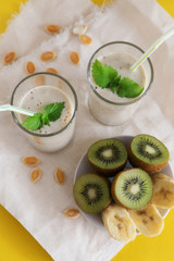 Fruit smoothie in glasses with milk, banana and kiwi
