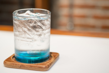 Glass of water with ice on the white table at restaurant.