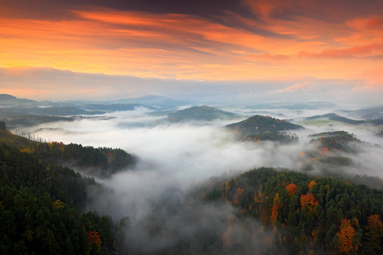 Fototapeta Hills and villages with foggy morning. Morning fall valley of Bohemian Switzerland park. Hills with fog, landscape of Czech Republic, landscape from Ceske Svycarsko. Czech typical autumn landscape.