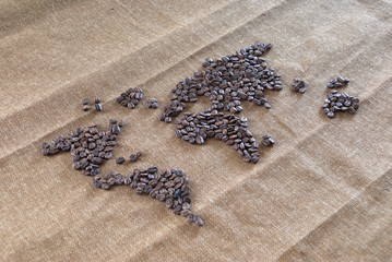 Map mundi formed with roasted coffee beans from Guatemala, on organic texture.