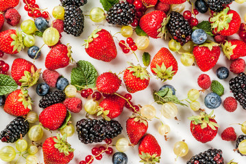 Summer fruit and berries. 6 types of raw organic farmer berries - raspberries blackberries blueberries strawberries red currants gooseberries. On white marble table. Copy space top view
