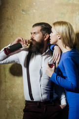 Girl with glass of liqueur looking at man drinking wine