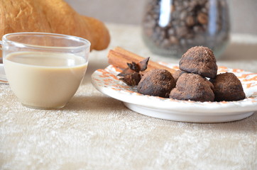 Chocolate truffles with and cinnamon. Candy, chocolate, Croissant and a cup of coffee