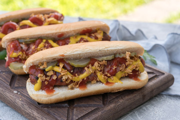 Hot Dog with grilled bacon wrapped sausage, ketchup, yellow mustard, fried onion and pickles
