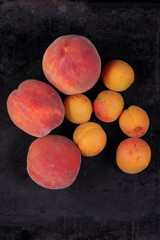 Peaches, apricots and pear - fruit platter on a dark background