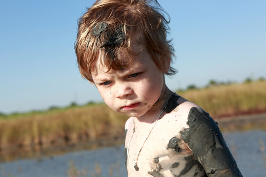 Serious kid in healing mud