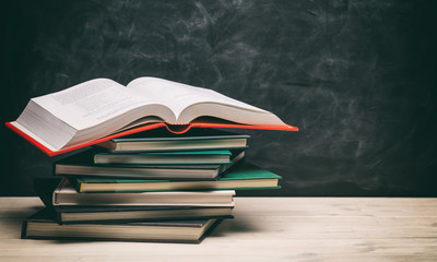 Books stacks on blackboard background
