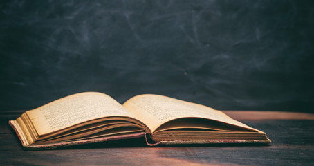 Vintage book on blackboard background