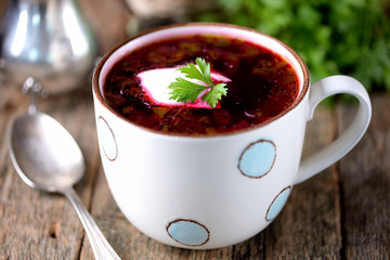 Traditional Ukrainian soup borsch on an old wooden background. Rustic style.