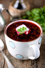 Traditional Ukrainian soup borsch on an old wooden background. Rustic style.
